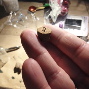 Poke headpin through cork for your vial from bottom; cut off and bend headpin to create loop that will allow you to insert ornament hook or ribbon.