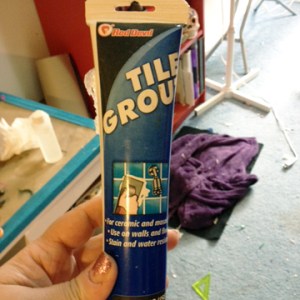 Use silicone tile grout to adhere your tree into the bottom of your vial taking care to not get the grout on the sides [Tip: I used a disposable piping bag to get the grout into the bottom of the vial without glopping it all over.]