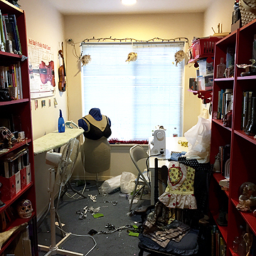 In this wider view you can see the “library” section of her studio that is the divider between the sewing and art areas of her studio.